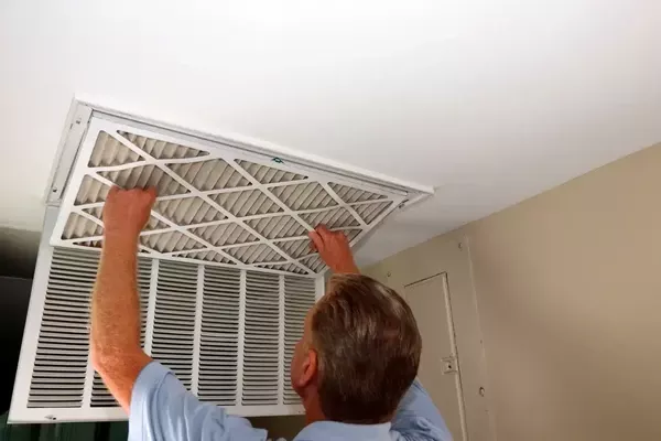 Replacing a ceiling air filter during spring home maintenance for improved airflow and efficiency