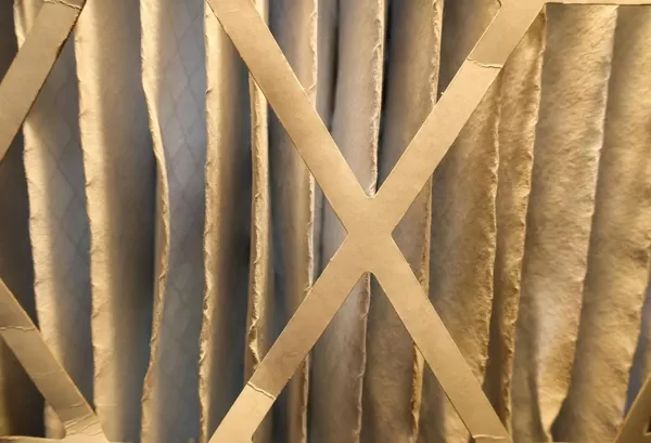 Close-up of pleated HVAC air filter showing dust buildup and filtration layers for indoor air quality